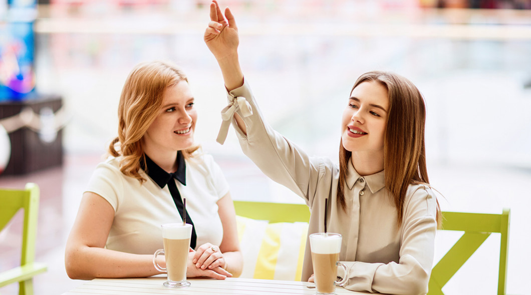 Image of two people sitting at a cafe and drinking coffee