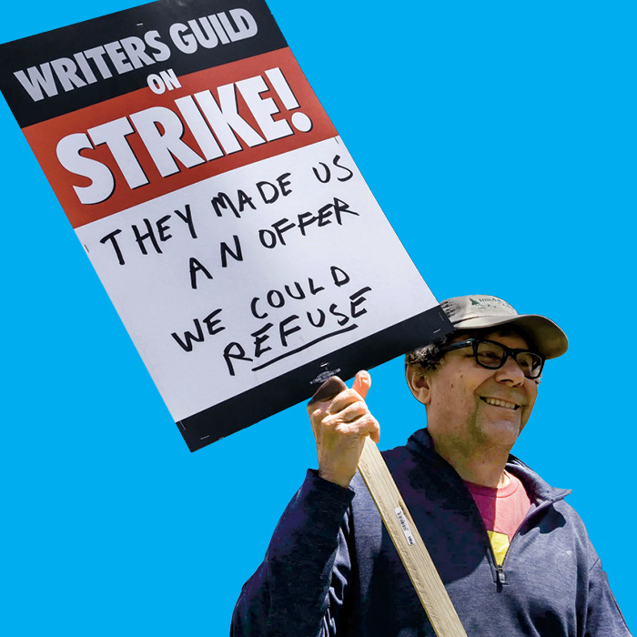 Image of a protestor holding a sign, Writers Guild On Strike, they made us an offer we could refuse