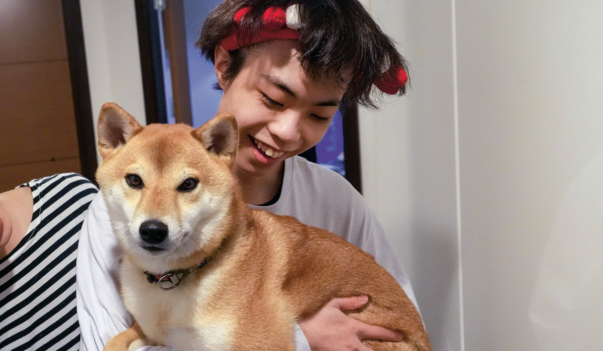 Photo of a kid smiling with their dog