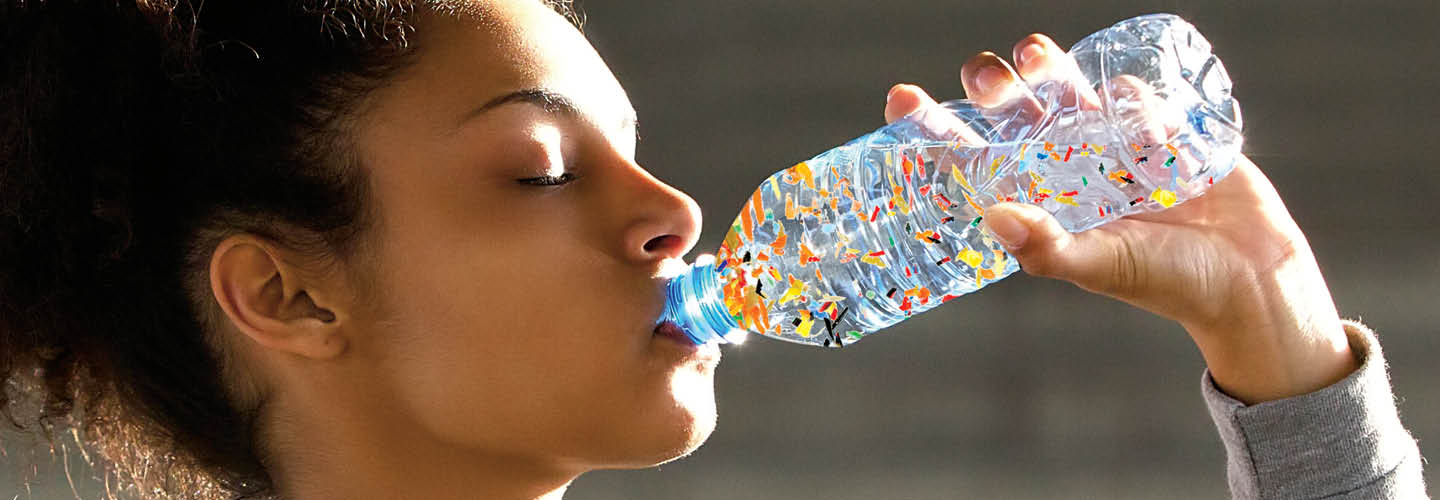 Image of person drinking from water bottle with tiny microplastics in it